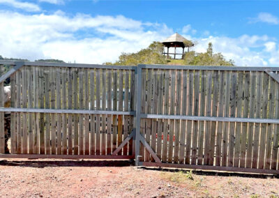 Portail et clôture en bois installés par l’Entreprise Quinty sur un site minier en Nouvelle-Calédonie, illustrant la sécurisation et la délimitation d’un accès professionnel.