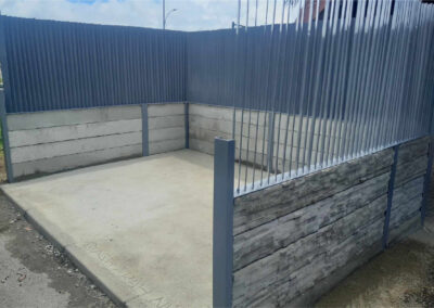 Local à poubelles en béton avec bardage et structure métallique réalisé par l’Entreprise Quinty, illustrant un aménagement extérieur fonctionnel et durable.